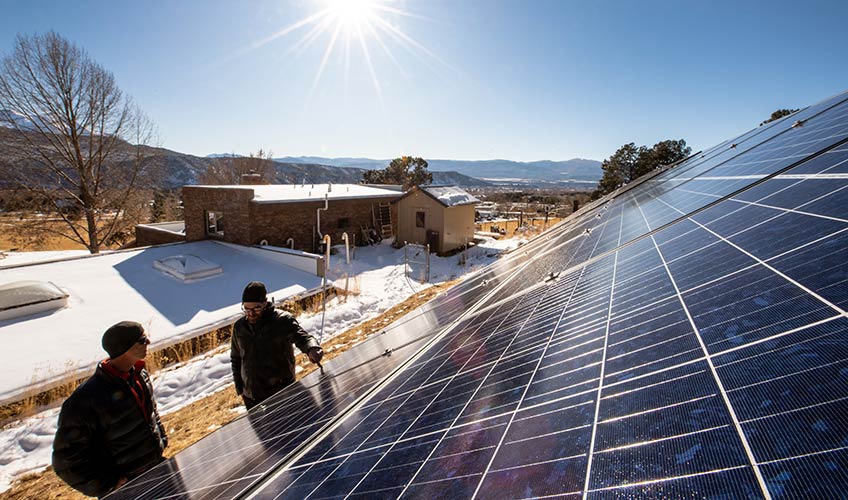 Photo of two people next to a residential solar installation