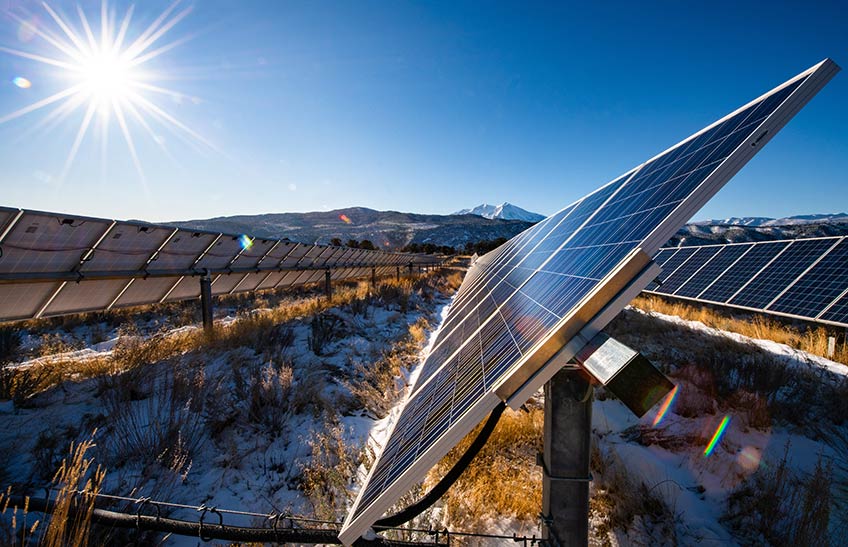 Solar panels with mountains in the background.