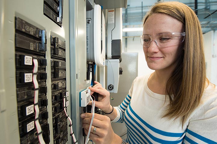 Bethany Sparn works on a circuit breaker service box within lab.