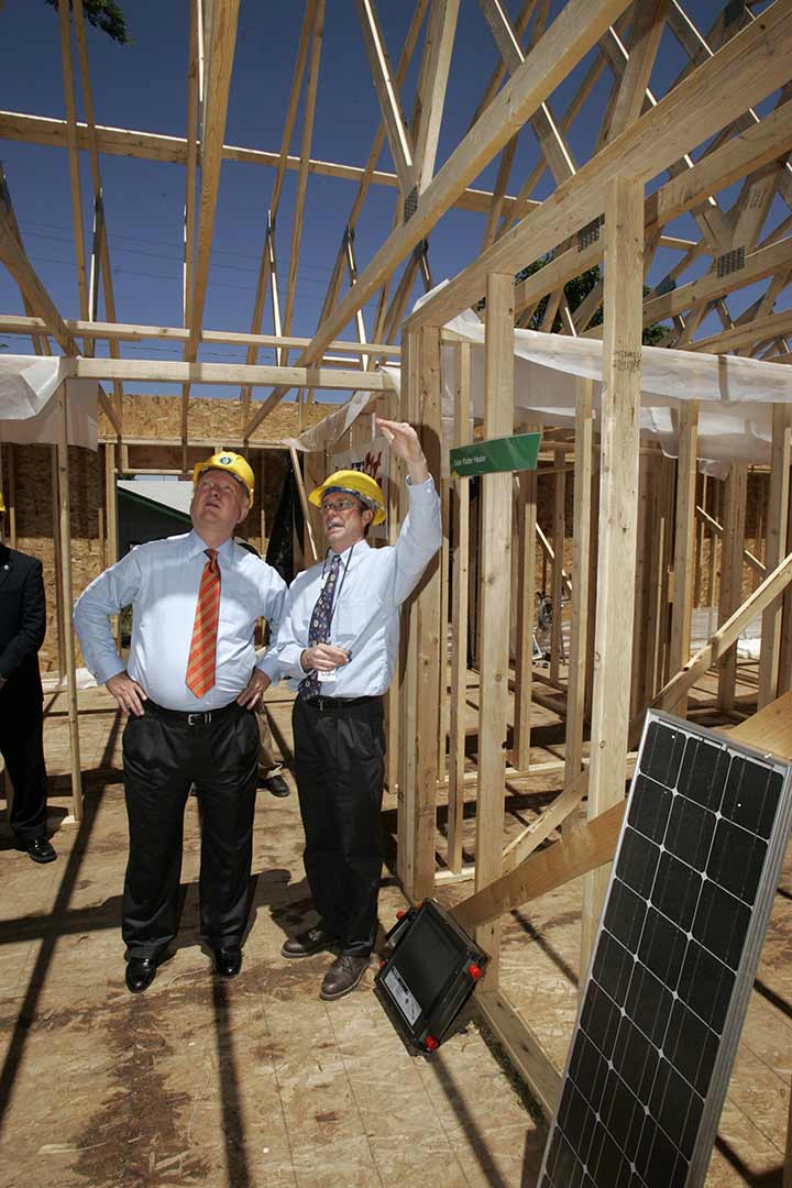 Two people on a construction site of a house.