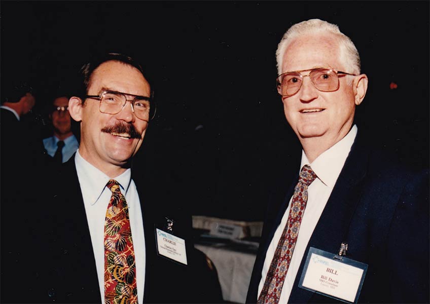 Two men smiling at a clean energy conference.