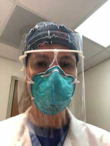 A selfie of a doctor wearing a face shield.