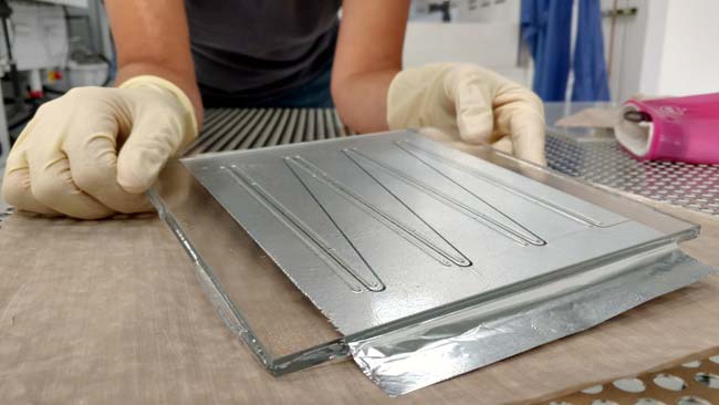 Close-up photo of hands holding a back-contact solar cell.