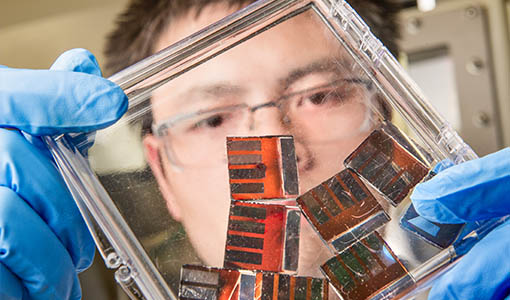 A researcher works with hybrid perovskite solar cells in a lab.