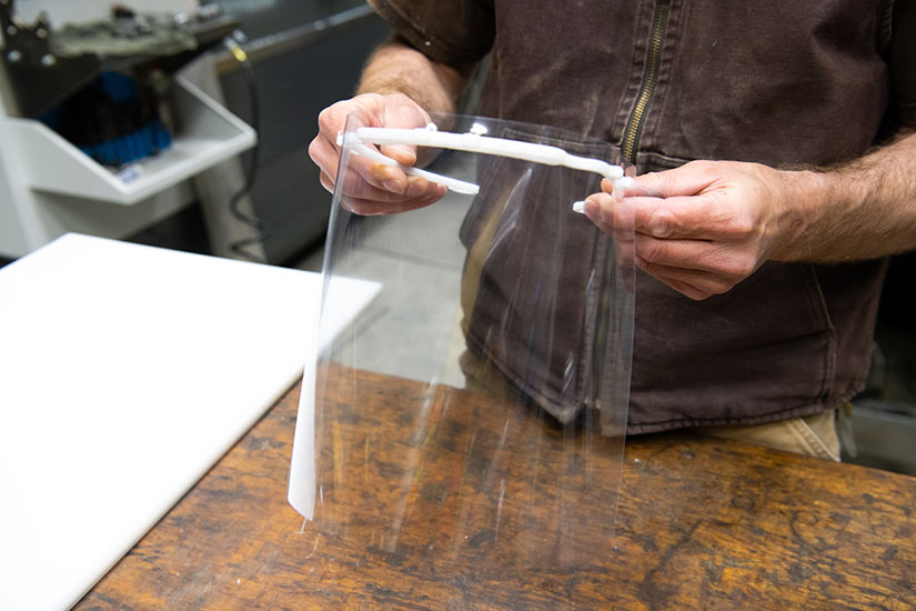 Photo of a person's hands holding a face shield