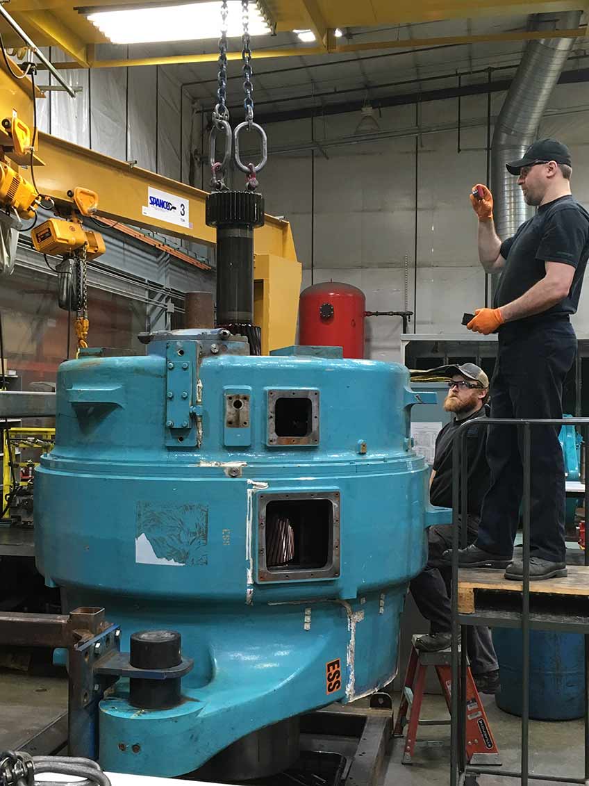 Wind plant operators disassemble and inspect a General Electric Transportation System wind turbine gearbox for damage. 