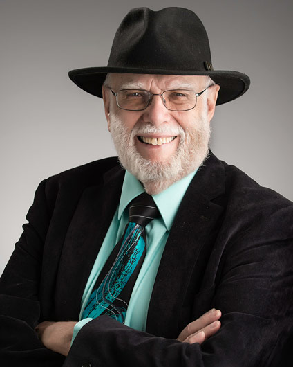 Photograph of a smiling man, Bob Thresher, in a black fedora style hat.
