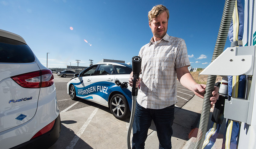 Man standing at a hydrogen fuel station.