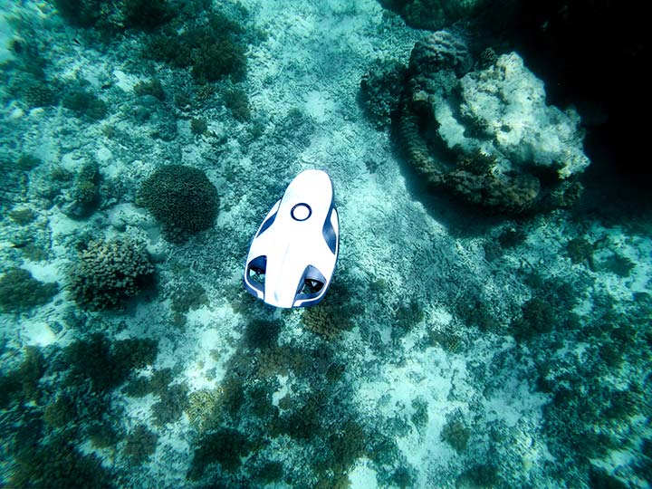 An autonomous underwater vehicle floats deep in the ocean seabed.