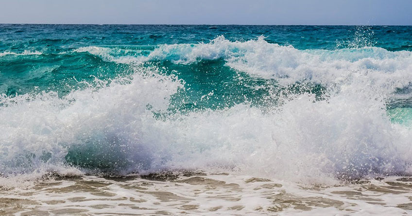 Photo of ocean waves crashing on the beach.