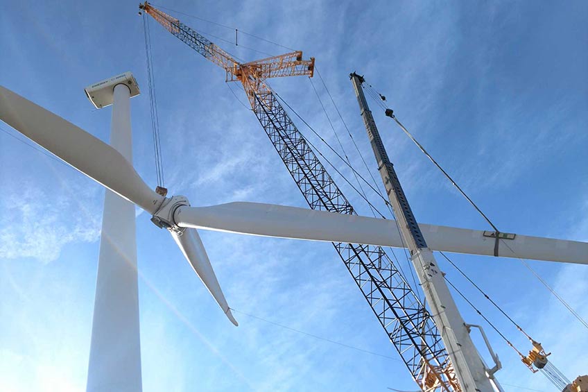 Photograph of a crane lowering a wind turbine rotor. 
