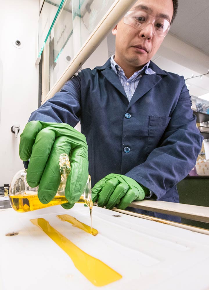 Researcher pouring resin into a mold.