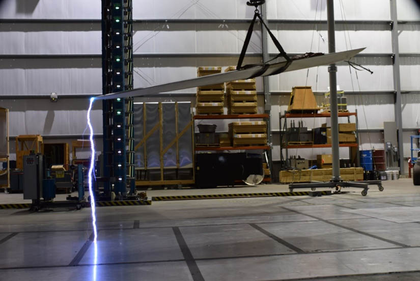 lightning arcing to concrete floor from wind turbine blade tip suspended from chain 