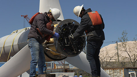 Workers install a data acquisition system on a tidal turbine