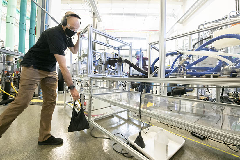 Photo of two researchers testing vehicle charing equipment in a lab