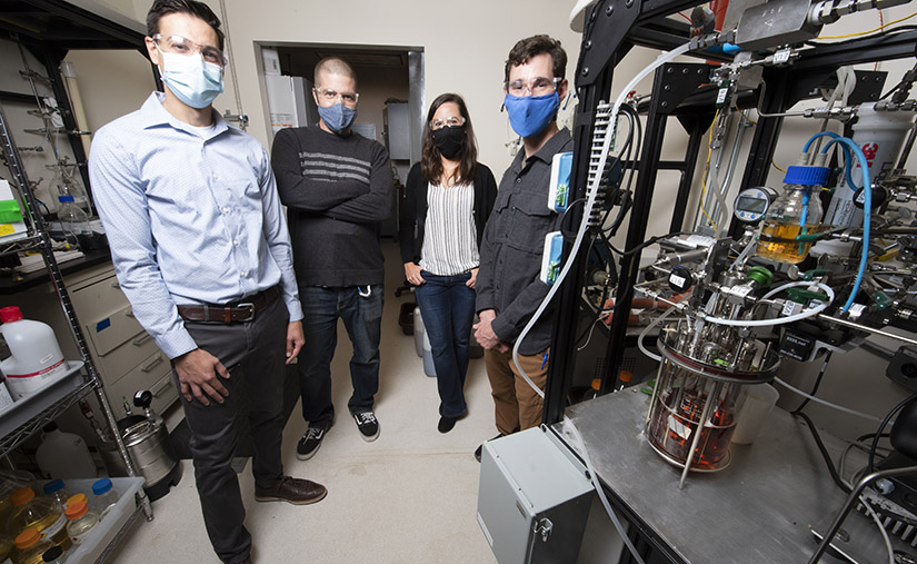 Four researchers stand in a lab