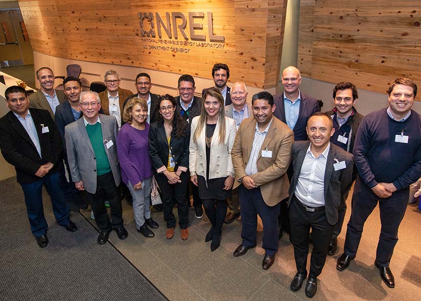 Photo of a group of international visitors in the entrance of the National Renewable Energy Laboratory’s Golden Campus.