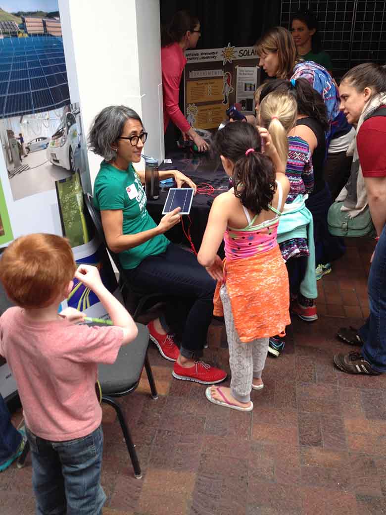 Children looking at a poster held by Alberta Carpenter