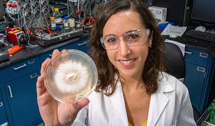 A woman holding up a research sample.