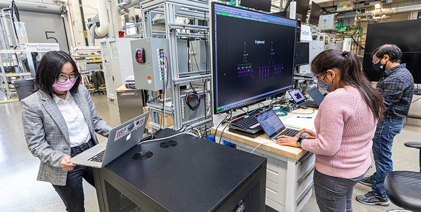 Picture of NREL researchers working on NREL’s advanced distribution management system test bed.