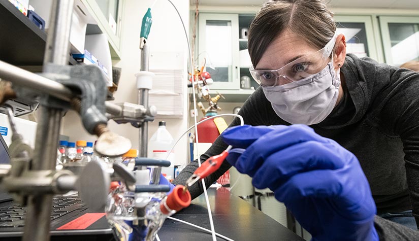 A woman in a lab working with equipment.