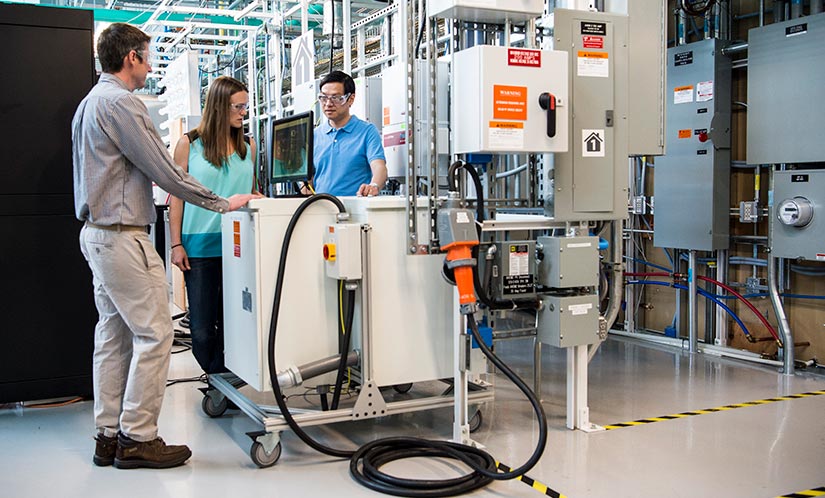 Three researchers standing in a lab.