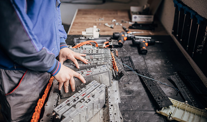 Photo of lithium-ion batteries from an electric vehicle on a table in a mechanic’s workshop.