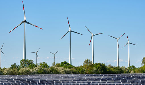 Solar panels in front of wind turbines