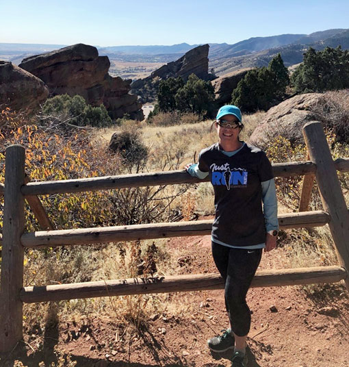 A photo of Kristin Munch on a trail during a run.