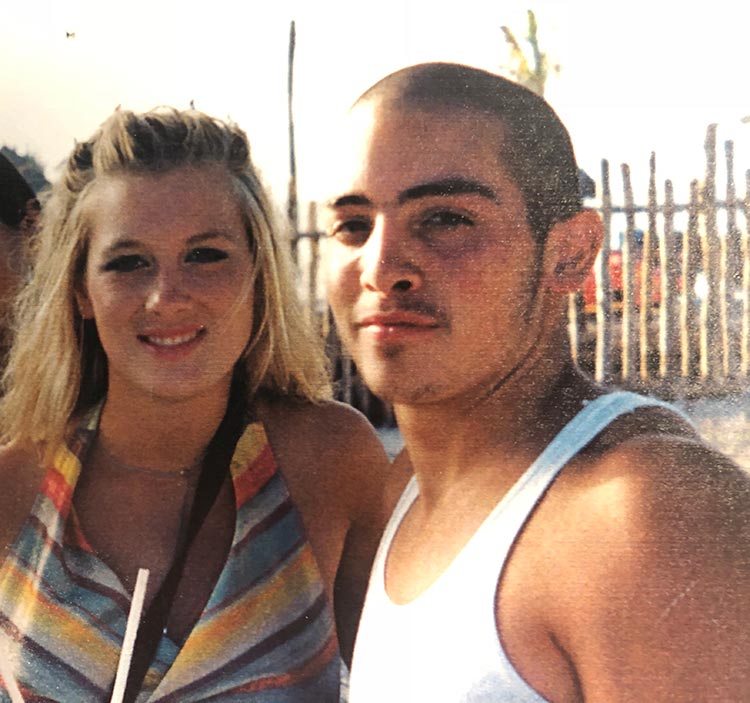 Photo of a young couple smiling at the camera.