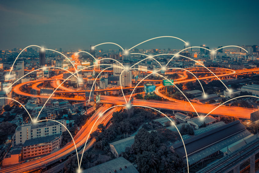 A photo of a lit-up metropolitan area with digitally inserted lines indicating connection points. NREL's microgrid research is exploring connections within the larger electric grid.