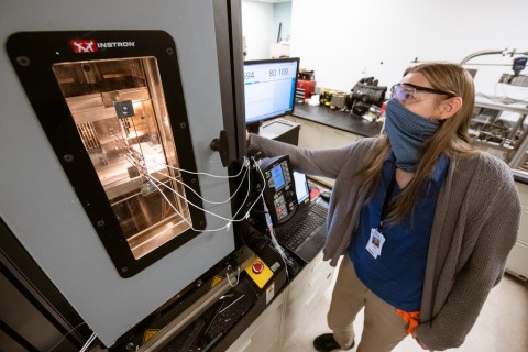 A woman operating lab equipment. 