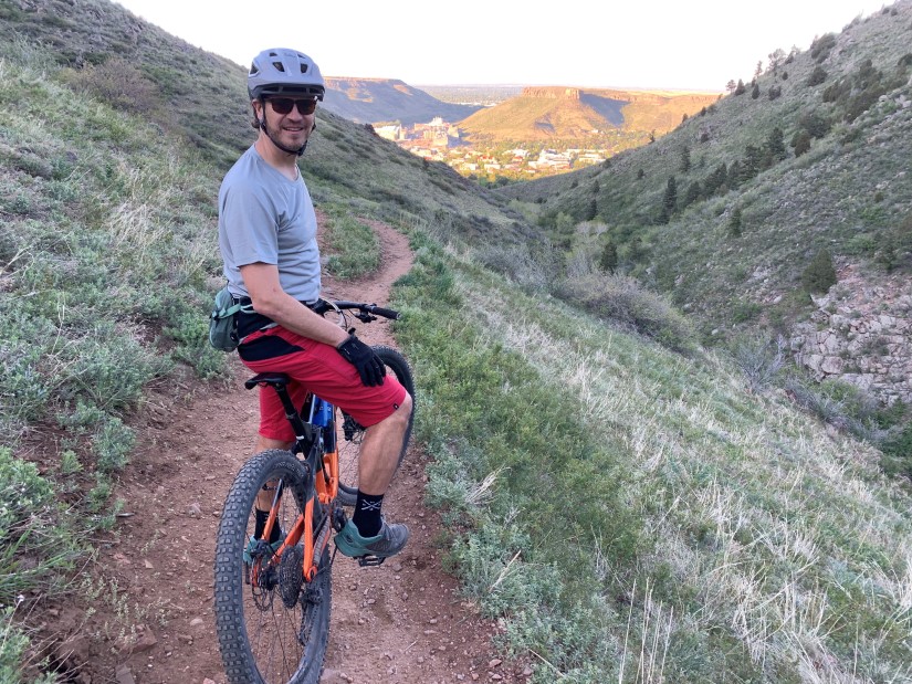 Kandler Smith stands with a bicycle on a trail. 