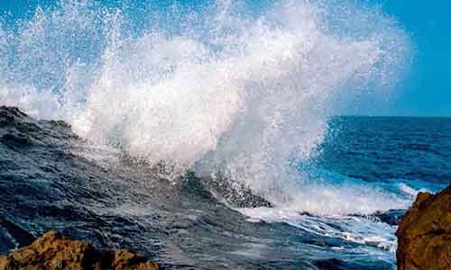 A wave crashes against rocks