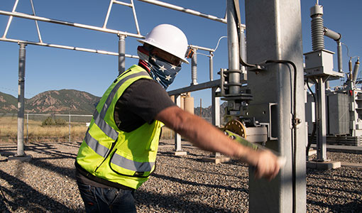 Photo of a technician operating an electrical substation