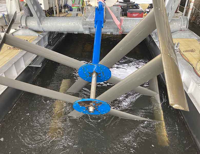 A vertical-axis turbine lifted halfway out of water