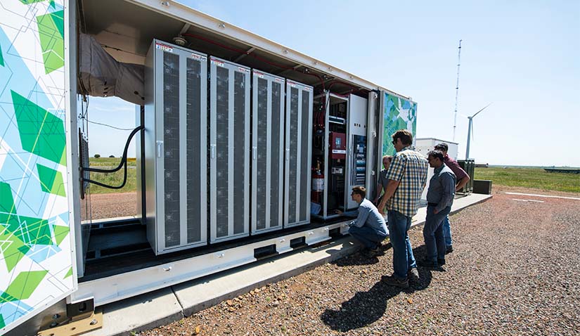 Researchers observing a battery energy system.