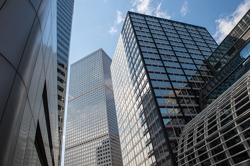 Photo shows glass facades of skyscrapers in downtown Denver.