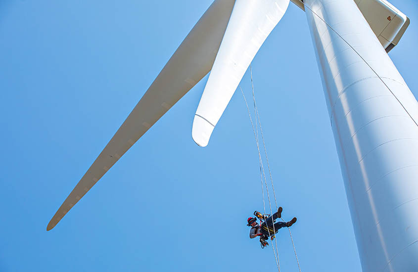 A person rappelling from a wind turbine.