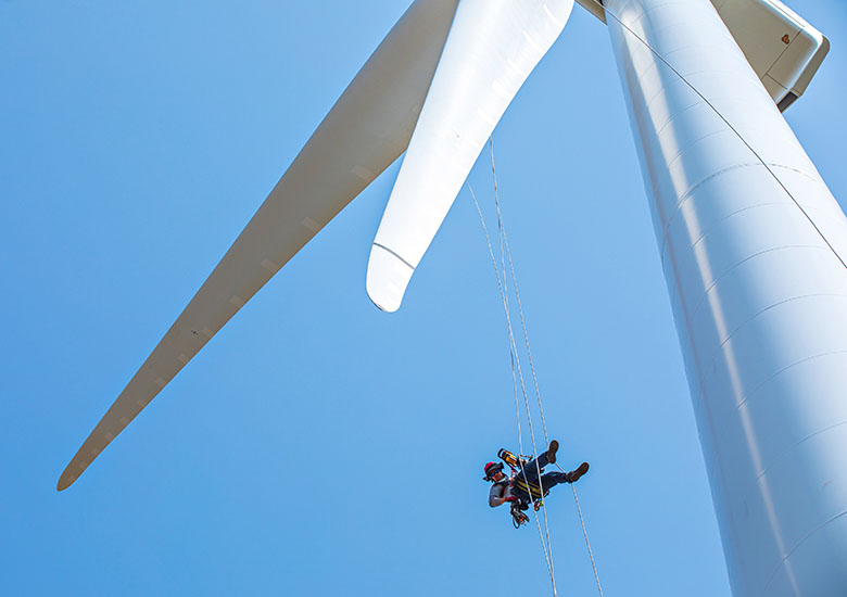 A worker rappelling off a wind turbine blade.