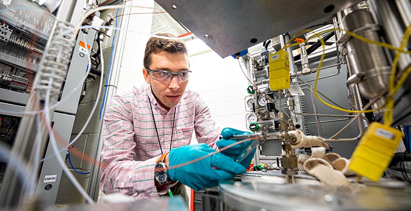 A scientist works on a reactor in a laboratory.