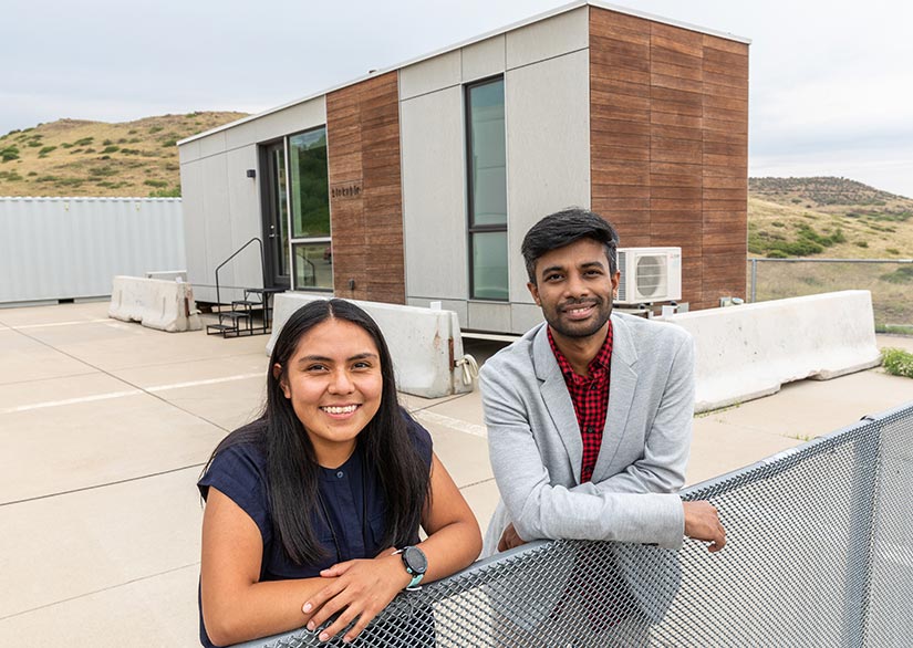 Researchers pose in front of a modular building testing site.