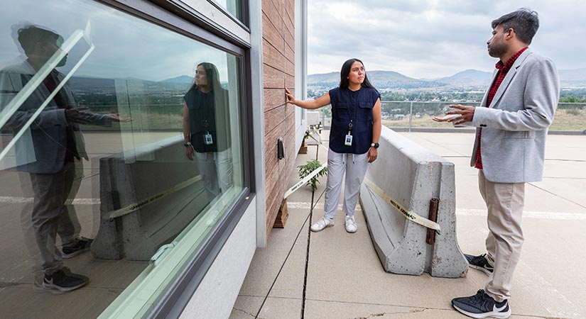 Researchers inspect a modular home at a testing site outside of NREL.