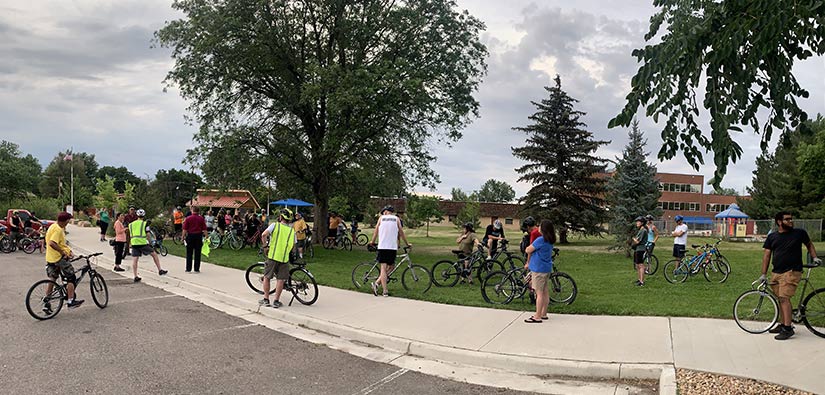 People with bikes standing in a park.