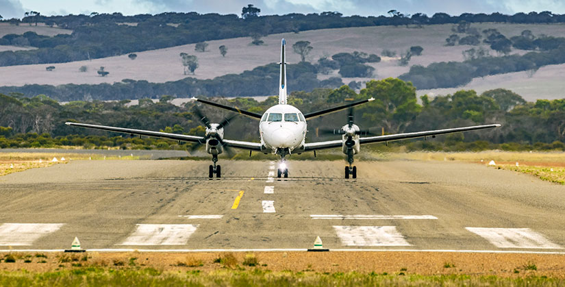 A small plan sitting on a runway. 