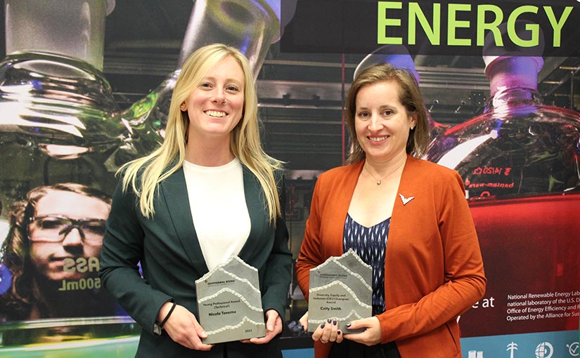 Two people smiling and holding awards.