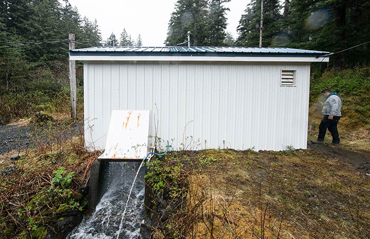 White shed structure with water flowing through an open shaft