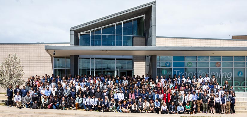 More than 300 students stand in front of a building on the National Renewable Energy Laboratory campus for a group photo.