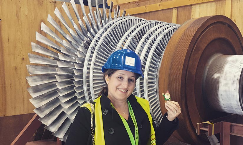 A woman standing in front of power station equipment.
