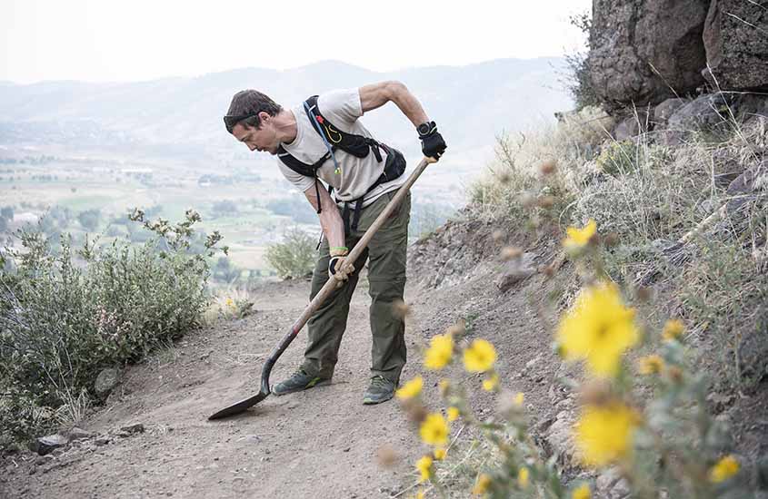 Stuart Cohen shoveling debris off a mountain trail.